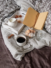 cozy evening with a book and cookies under the covers. Interior details. Coffee in bed