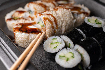 Sushi rolls with cream cheese, nori and cucumber covered with eel, sesame and caramel sauce....