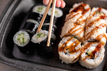 Sushi roll with cucumber, cream cheese, eel and unagi sauce. Japan restaurant menu. selective focus