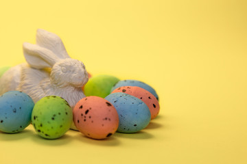 Colorful easter eggs painted in pastel colors and white rabbit hare toy