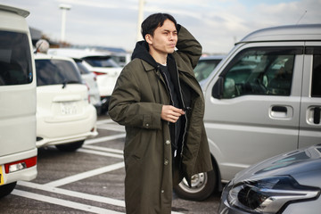 駐車場で車を探す男性