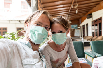 Beautiful portrait selfie of tourists with face masks sheltering for volcanic ash in Sumatra, Indonesia