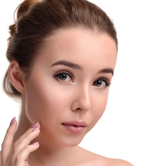 Fototapeta premium Beauty skin. Young beautiful woman with naked shoulders touching her face on white background. Girl with Clean Fresh Skin. Close up. Cosmetology. Skincare. Beauty & Skin care concept. Copy space