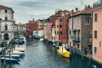 Canal with boats and colorful houses in Chioggia near Venice in Italy