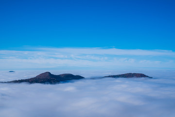 Fototapeta na wymiar Germany, Perfect aerial view above endless fog clouds in valley of swabian jura nature landscape on a sunny day with blue sky near stuttgart, mountains like islands