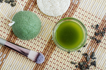 Fototapeta na wymiar Homemade natural face toner (infusion, tincture) with matcha powder. Diy green tea cosmetics recipe. Top view, copy space 