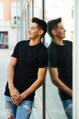 Fototapeta premium Young man leaning on a window pane.