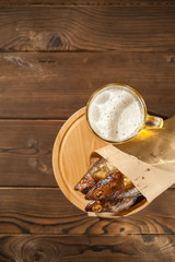 Beer glass with beer and hot smoked fish close-up. Beer mug with beer and fish on a dark background and copy space.