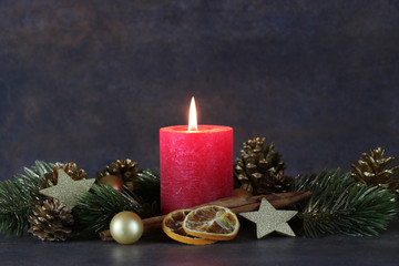 Adventsdekoration mit roter Kerze und Weihnachtsschmuck