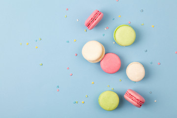 Cake macaron or macaroon on blue background, colorful almond cookies. French almond cookies on dessert top view.