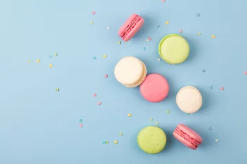 Fototapete Macarons Kuchen Makronen oder Makronen auf blauem Hintergrund, bunte Mandelplätzchen. Französische Mandelplätzchen auf Draufsicht des Desserts.