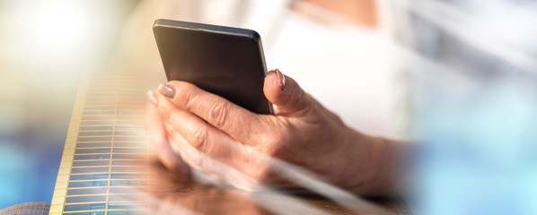 Woman's hands using a mobile phone; multiple exposure