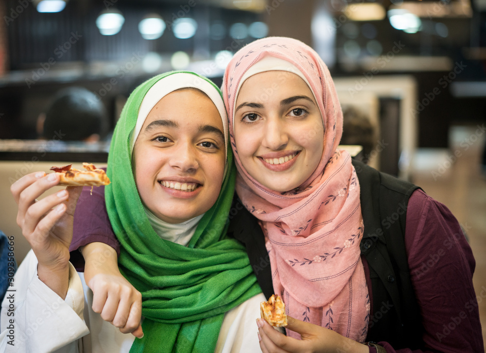 Wall mural muslim girls at restaurant waiting for iftar