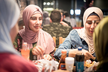 Muslim girls at restaurant having iftar