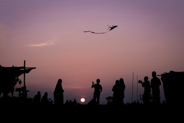 Naklejka na ściany i meble silhouettes of people at sunset