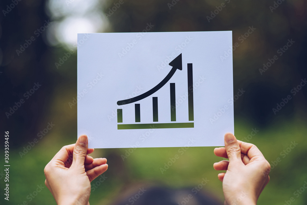 Poster show business paper graph statistics,arrow showing the chart in hand on nature background