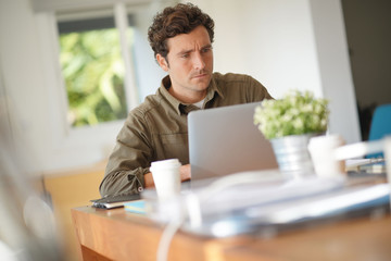 Man using laptop computer in co-working office
