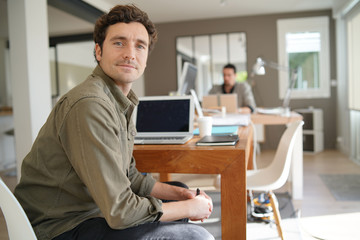 Man using laptop computer in co-working office