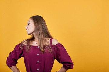 Young girl in burgundy bluse with bow suffering from backache of having made an effort. Behind her...