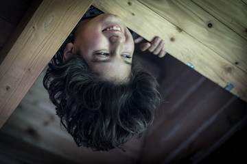 Upside down boy in wooden cottage