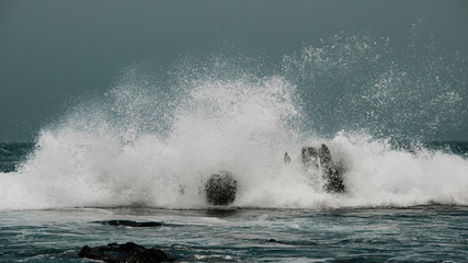 Naklejka premium waves crashing on rocks