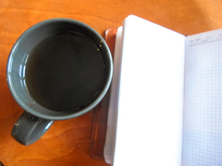 Office desk with a cup of tea and notepad