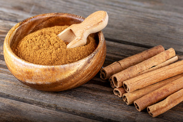 Cinnamon sticks and cinnamon powder on wood
