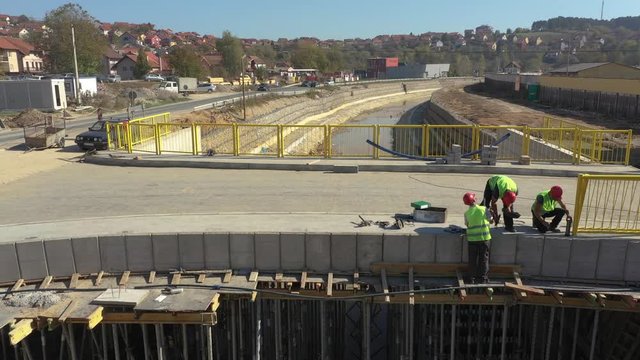 Areal close up shot of workers on construction on bridge. Sunny day