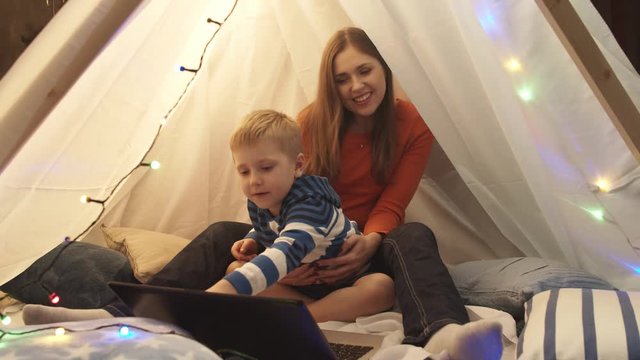 Little boy playing in children's tent at home. Happy caucasian kid in the playroom.