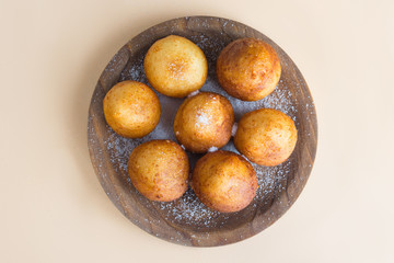French doughnuts Beignet covered with sugar powder on a brown background