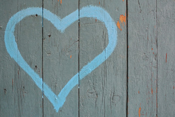 Blue heart painted on a wooden fence