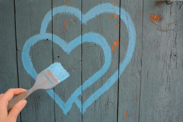 Two blue hearts painted on a wooden fence