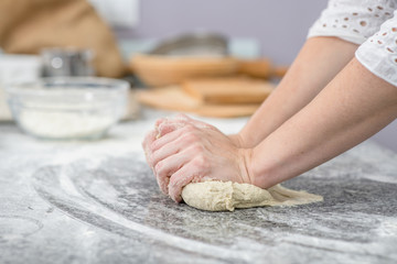 Female hands making dough in the kitchen at home