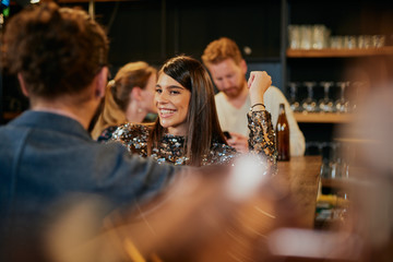 Young handsome caucasian couple standing in bar, chatting and flirting and having great time.