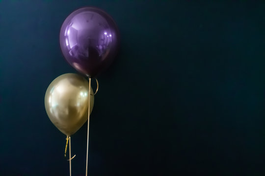 golden balloon and violet balloon on a dark background. Holiday Concept, Postcard