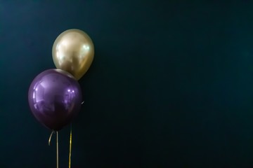 golden balloon and violet balloon on a dark background. Holiday Concept, Postcard