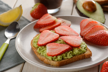 Toast with mashed avocado and sliced strawberry
