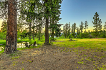 Obraz premium Summer mountain home large property with water canal and pond.