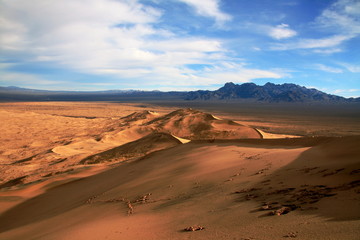 Massive sand dunes in Death Valley National Park desert in the winter golden and blue sky