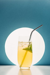 fresh lemonade with mint and straw on blue background with back light