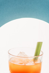 close up view of bloody Mary with celery on blue background with back light