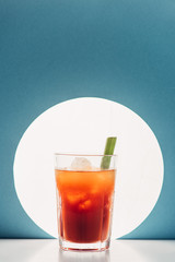 bloody Mary with celery on blue background with back light