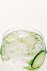 close up view of fresh gin and tonic with cucumber slices isolated on white