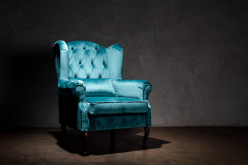 elegant velour blue armchair near grey wall