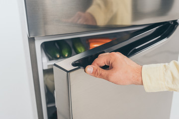 cropped view of man open fridge door