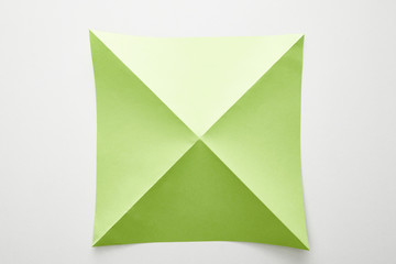 top view of empty green origami paper on white background