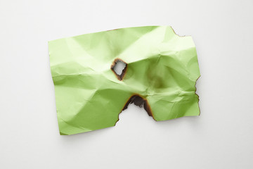 top view of empty crumpled and burnt green paper on white background