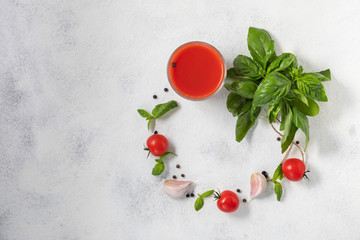 Organic fresh tomato juice in a glass on a light background, the concept of vegetables. View from above.