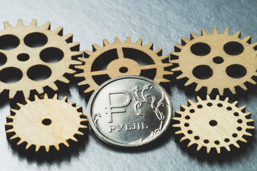 Russian coin and wooden gears macro on metal background, business concept in Russia