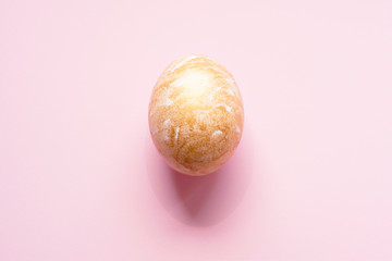 Easter egg painted gold on a pink pastel background